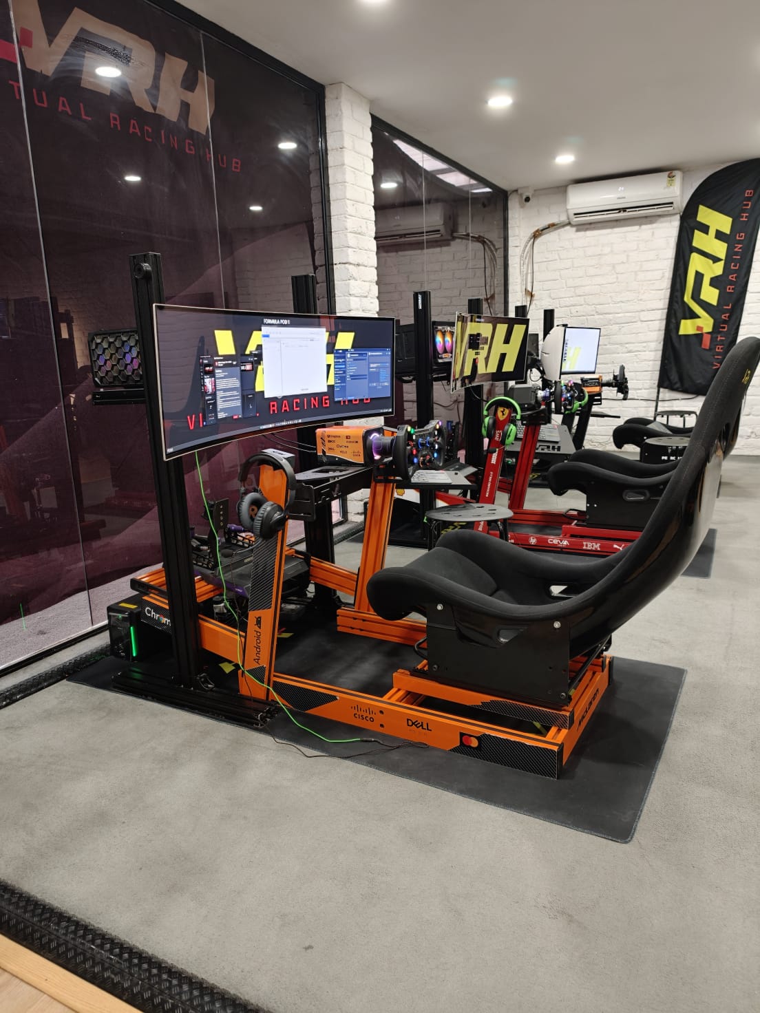 McLaren-liveried formula racing simulator pods at the Virtual Racing Hub sim racing lounge